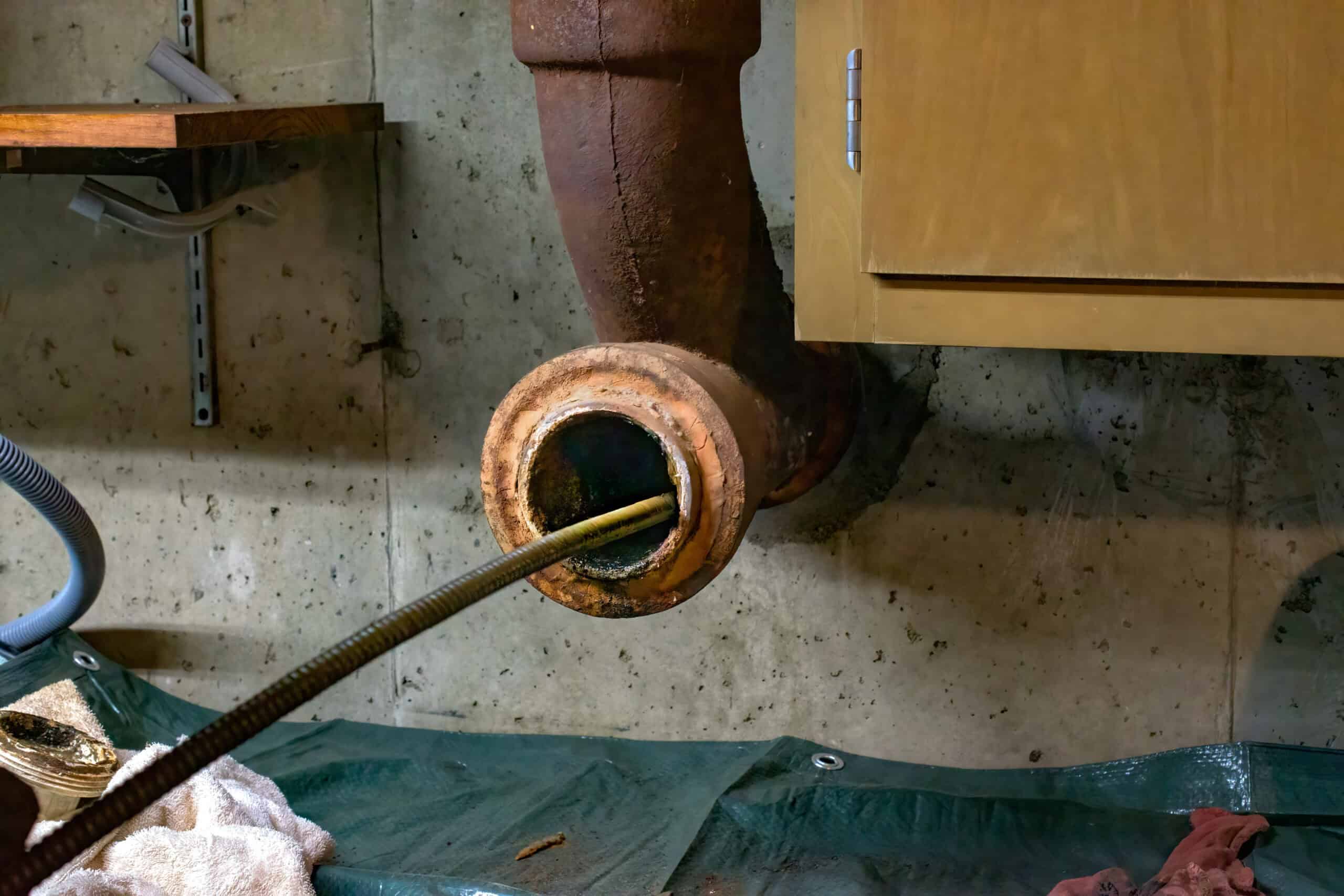 sewer drain auger clearing main sewer line clog in basement Hamilton home